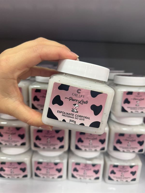 Esfoliante corporal Puro Leite na mão, com outros potes na prateleira